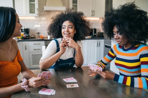 trīs meitenes mājās spēlē kārtis