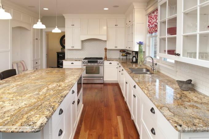 šajā plašajā virtuvē ir marmora letes un centrālais lete, satriecoši cietkoksnes skapji un grīda
